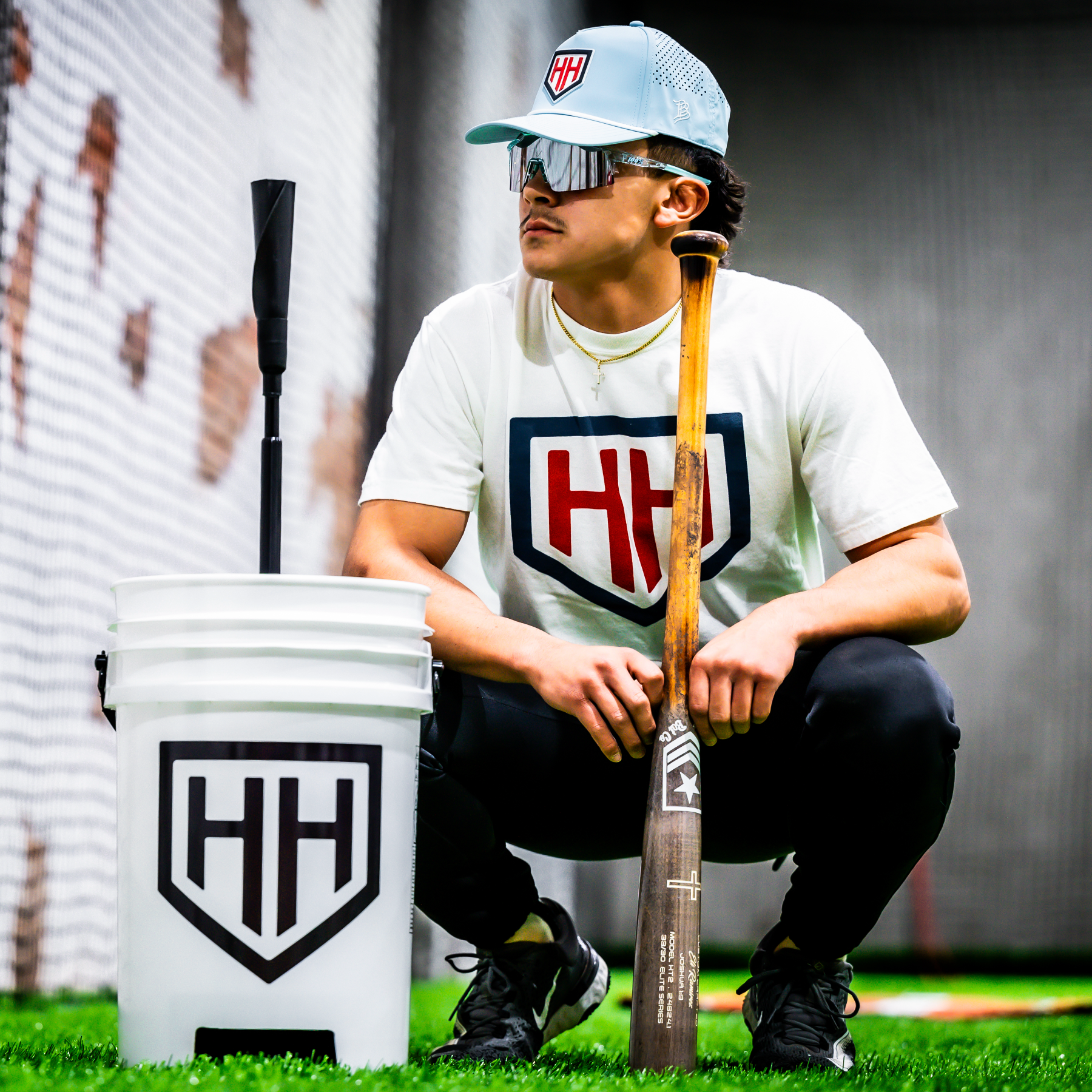 Baseball player wearing sunglasses crouched next to Home Run Hero bucket