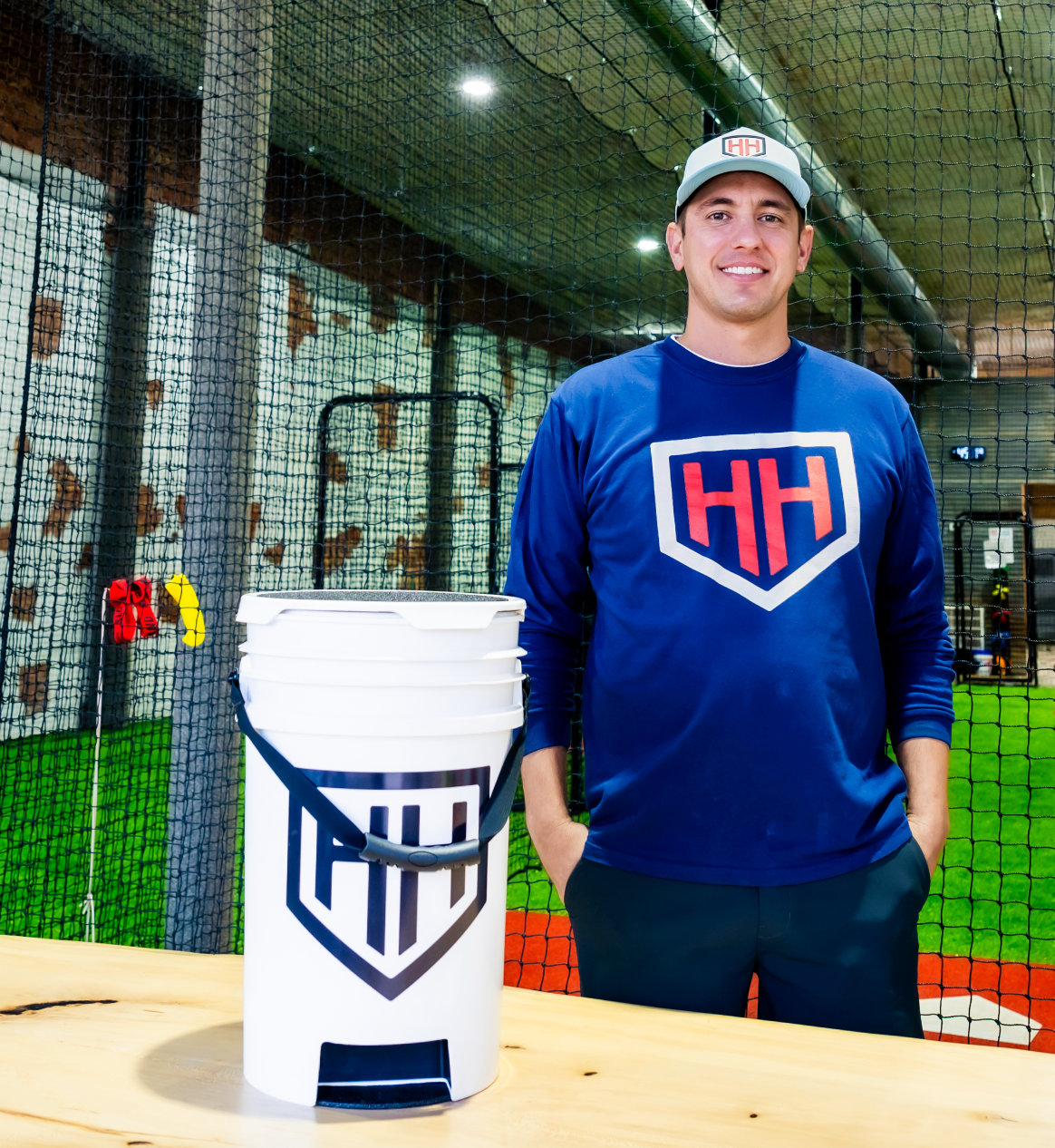 Coach Trey smiling with white Home Run Hero ball bucket