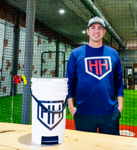 Coach Trey smiling with white Home Run Hero ball bucket