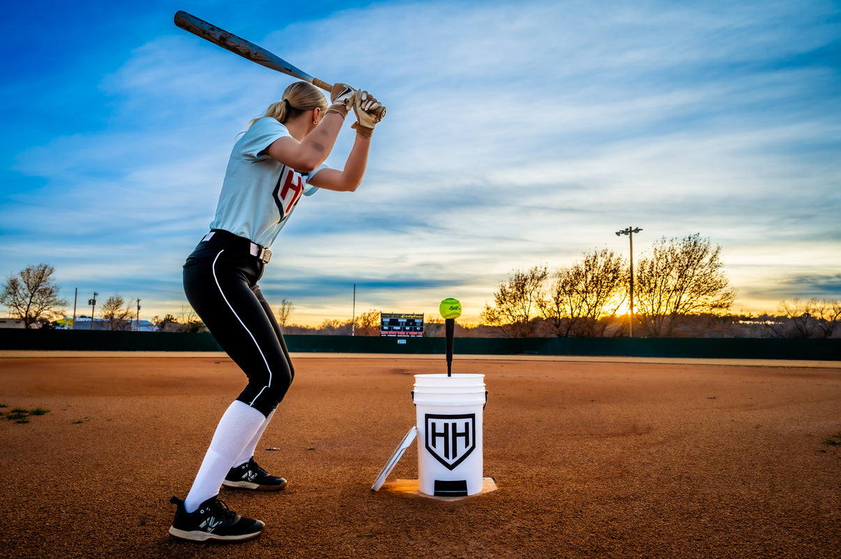 Softball player getting ready swing a bat and hit a softball off of Home Run Hero tee