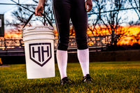 Softball player holding Home Run Hero bucket on softball field
