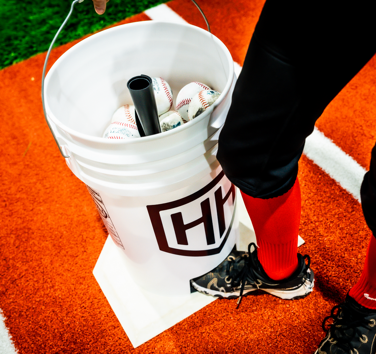 Baseball player lifting Home Run Hero bucket off of tee